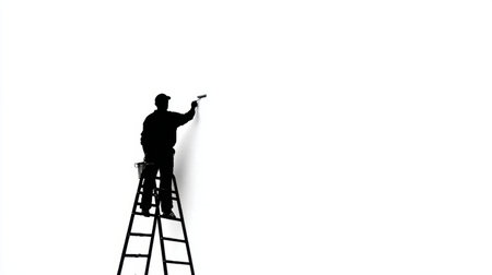 A mature man is using a paint roller to paint a wall while standing on a ladder in a simple setting. The background is white and clear.の素材