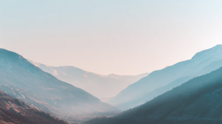 Mountain valley shows early spring bloom with gentle pastel haze covering hills and valleys under soft morning light.の素材
