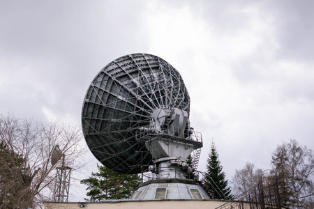 A large radio telescope stands prominently in a rural area, designed to receive radio signals from space.の写真素材