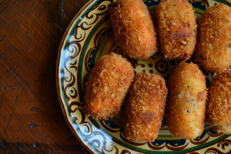 Savory fried croquettes served on a decorative plate, perfect for food and culinary themesの素材