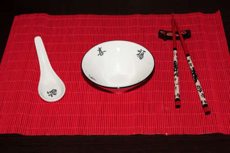 white ceramic bowl and wooden chopsticks isolated on white backgroundの写真素材