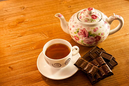 broken lines pieces of milk chocolate on the aged brown wooden background close planの写真素材