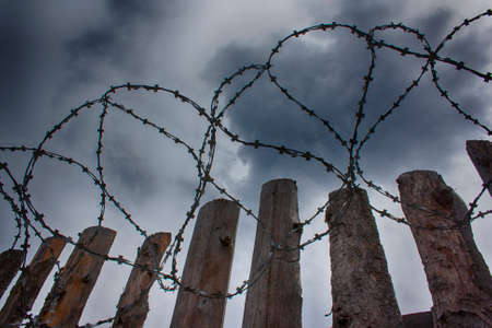 Barbed wire on the background of clouds overの写真素材