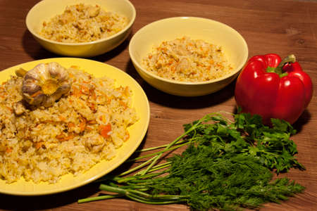 Pilaf on the clay plate on a wooden tableの写真素材