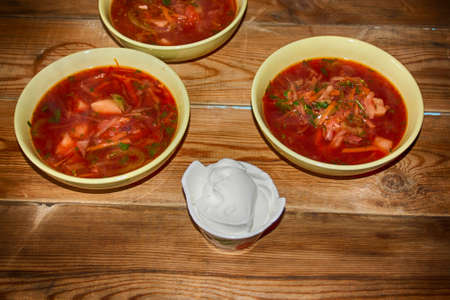 Goulash or stew in bowl served with parsley on wooden background, top view.の写真素材