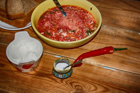 Goulash or stew in bowl served with parsley on wooden background, top view.