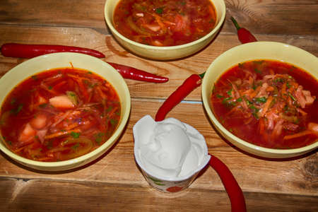 Goulash or stew in bowl served with parsley on wooden background, top view.の写真素材