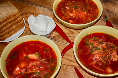 Goulash or stew in bowl served with parsley on wooden background, top view.の写真素材