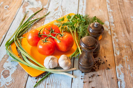 Fresh tomatoes with salad leaves on the table. Background.の写真素材