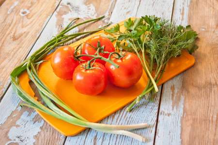 Fresh tomatoes with salad leaves on the table. Background.の写真素材