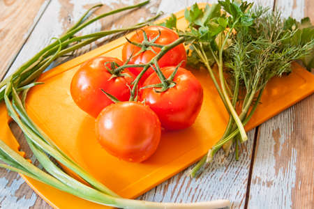 Fresh tomatoes with salad leaves on the table. Background.の写真素材