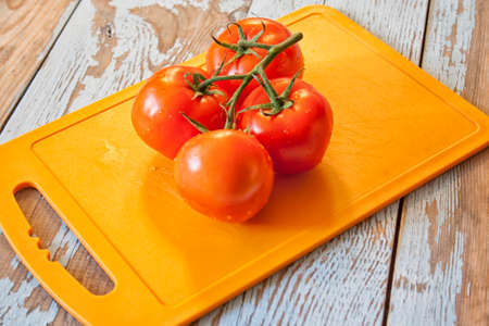 Fresh tomatoes with salad leaves on the table. Background.の写真素材
