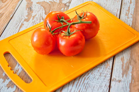 Fresh tomatoes with salad leaves on the table. Background.の写真素材