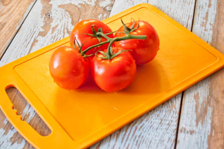 Fresh tomatoes with salad leaves on the table. Background.の写真素材