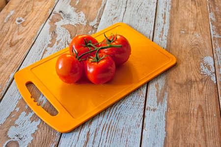 Fresh tomatoes with salad leaves on the table. Background.の写真素材