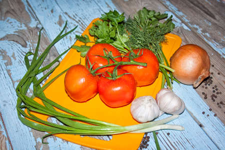 Fresh tomatoes with salad leaves on the table. Background.の写真素材