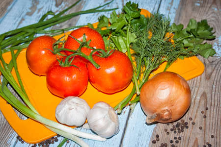 Fresh tomatoes with salad leaves on the table. Background.の写真素材