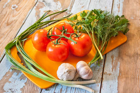 Fresh tomatoes with salad leaves on the table. Background.の写真素材