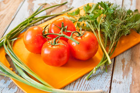 Fresh tomatoes with salad leaves on the table. Background.の写真素材
