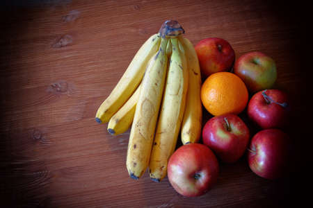 Fruit bananas apples orange on a wooden table backgroundの写真素材