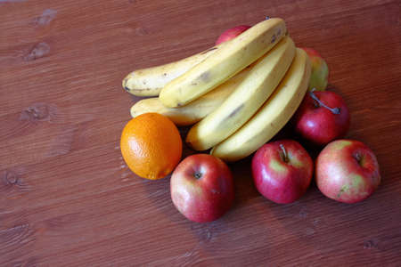 Fruit bananas apples orange on a wooden table backgroundの写真素材