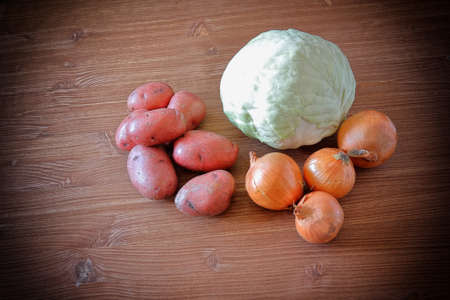 Set of vegetables cabbage potatoes carrots onion garlic parsley dill beet ginger on a wooden table backgroundの写真素材