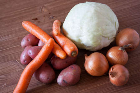 Set of vegetables cabbage potatoes carrots onion garlic parsley dill beet ginger on a wooden table backgroundの写真素材