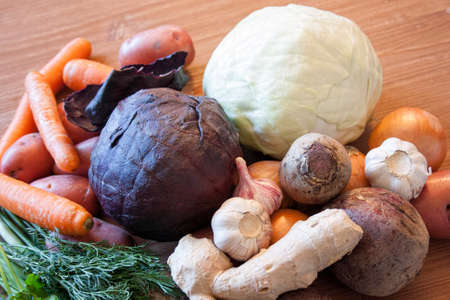 Set of vegetables cabbage potatoes carrots onion garlic parsley dill beet ginger on a wooden table backgroundの写真素材
