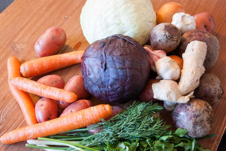 Set of vegetables cabbage potatoes carrots onion garlic parsley dill beet ginger on a wooden table backgroundの写真素材