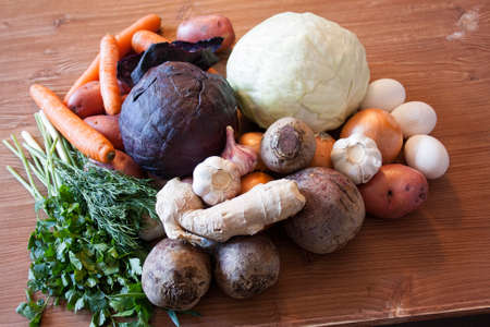 Set of vegetables cabbage potatoes carrots onion garlic parsley dill beet ginger on a wooden table backgroundの写真素材