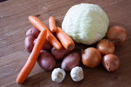 Set of vegetables cabbage potatoes carrots onion garlic parsley dill beet ginger on a wooden table backgroundの写真素材