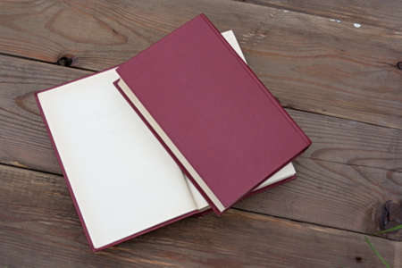 Two red books on the background of a wooden tableの写真素材