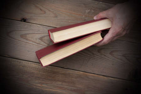 Two red books on the background of a wooden tableの写真素材