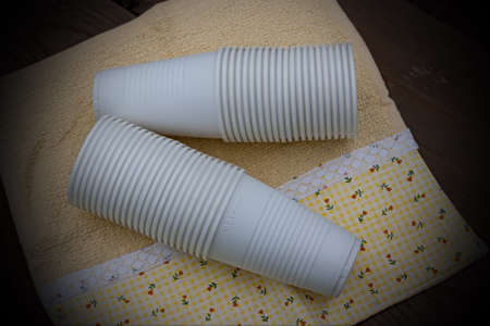 A stack of plastic cups on the background of a wooden tableの写真素材