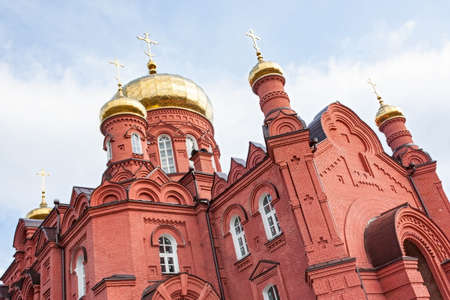 the old building of the Russian Orthodox Church in the city of Nizhny Tagil , red brick against the blue skyの写真素材