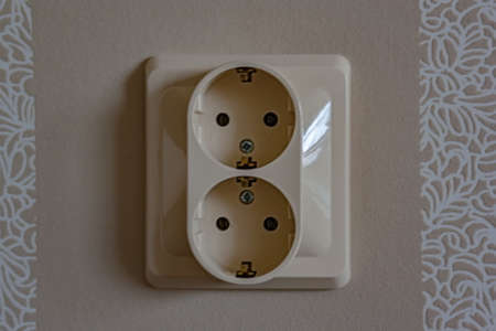 White electric socket on the wall. Close up.