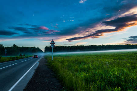 Sunset over fog in the forest summer evening