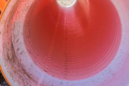 Pipes of PVC large diameter orange color prepared for laying on construction siteの写真素材