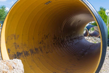 Pipes of PVC large diameter prepared for laying on construction siteの写真素材