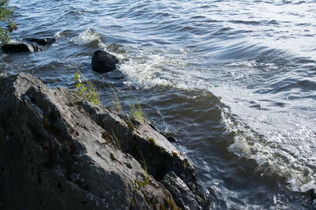 Waves of surf on the shore of the lake sunny summer dayの写真素材