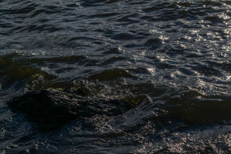 Waves of surf on the shore of the lake sunny summer dayの写真素材