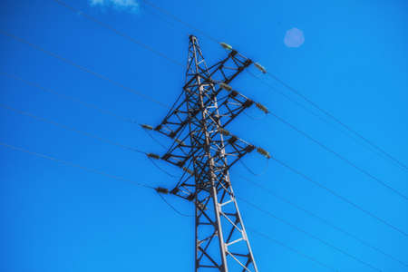 Supports high-voltage power lines against the blue sky. Electrical industry.の写真素材