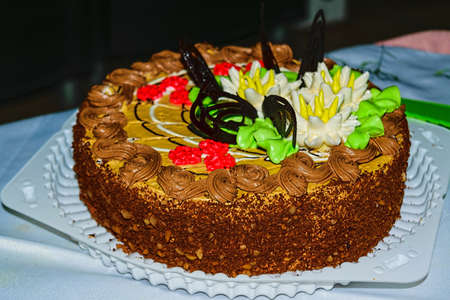 Biscuit cake with butter cream, nuts and chocolate glaze. Close up,top view.の写真素材