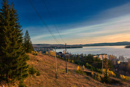View of the village of Chernoistochinsk Sverdlovsk region from the top of the mountain at sunset in autumnの写真素材