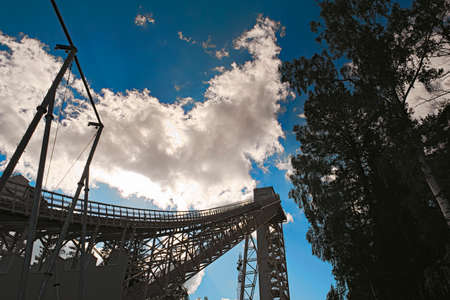 Metal structures of a large ski jumping-off against the sky and cloudsの写真素材