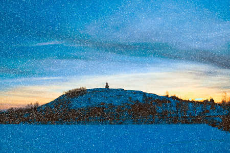 Winter sunset on the shore of the pond in the snowの写真素材