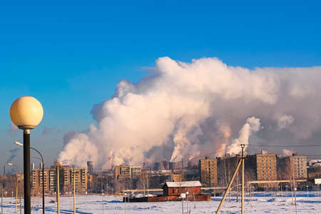 Emissions of the metallurgical plant against the background of the blue winter skyの写真素材