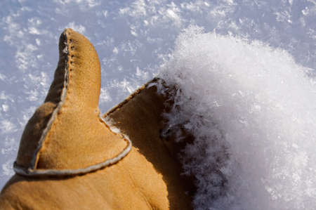 A womans hand holds fluffy snow on her palmの写真素材