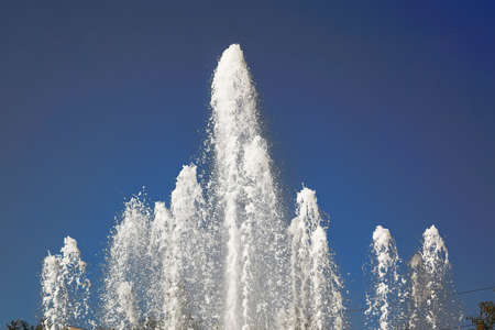 Fountain water jets against clear blue sky