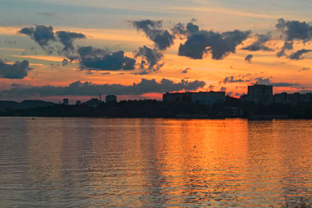 Summer landscape on the shore of a pond at sunsetの写真素材